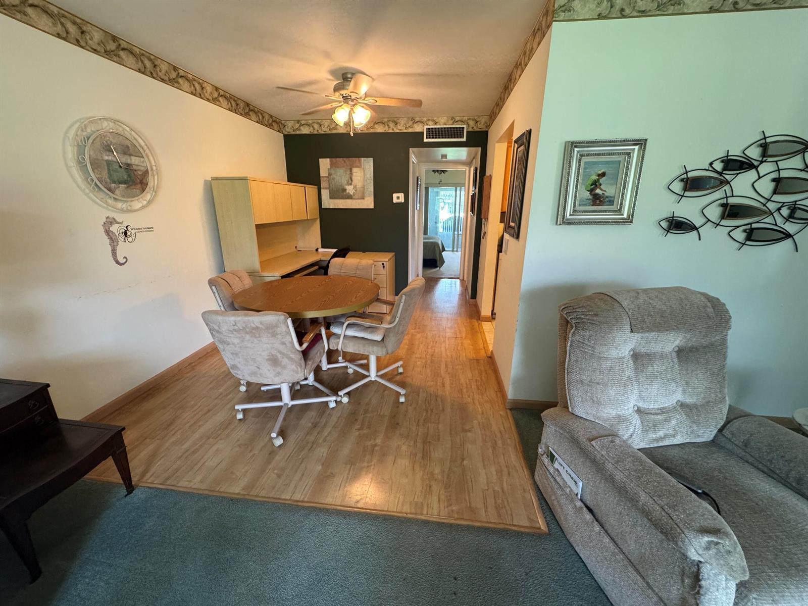 A dining area with a round table and chairs sits on wood flooring near a desk — 115 S South Boulevard # 1c, Boynton Beach FL 33435, BOYNTON BEACH, FL