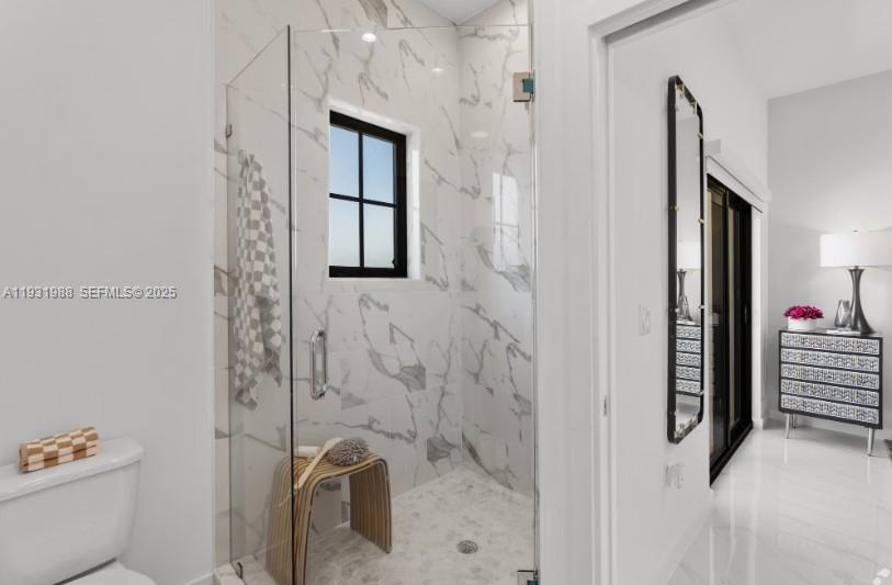 A bathroom features a glass-enclosed walk-in shower with marble-patterned tile walls and a small window — 2320 E 4th Ave # 102, Hialeah FL 33013, HIALEAH, FL