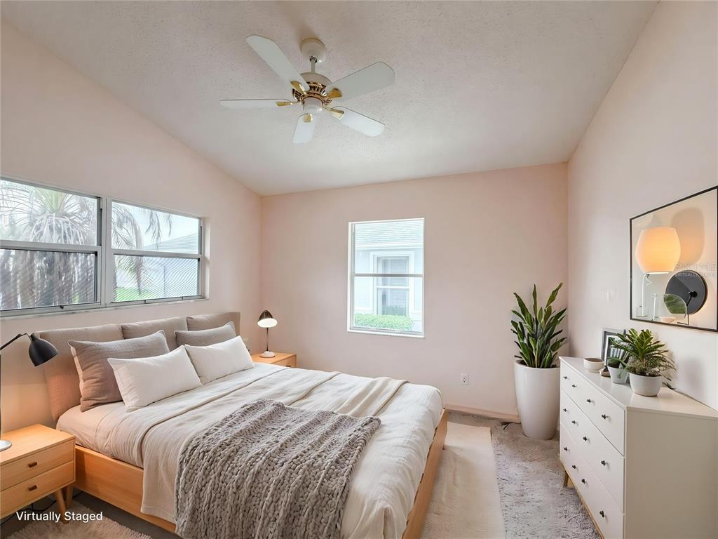 A bedroom with light pink walls, a bed, a dresser, and a ceiling fan — 5507 LAVER STREET, LEESBURG, FL
