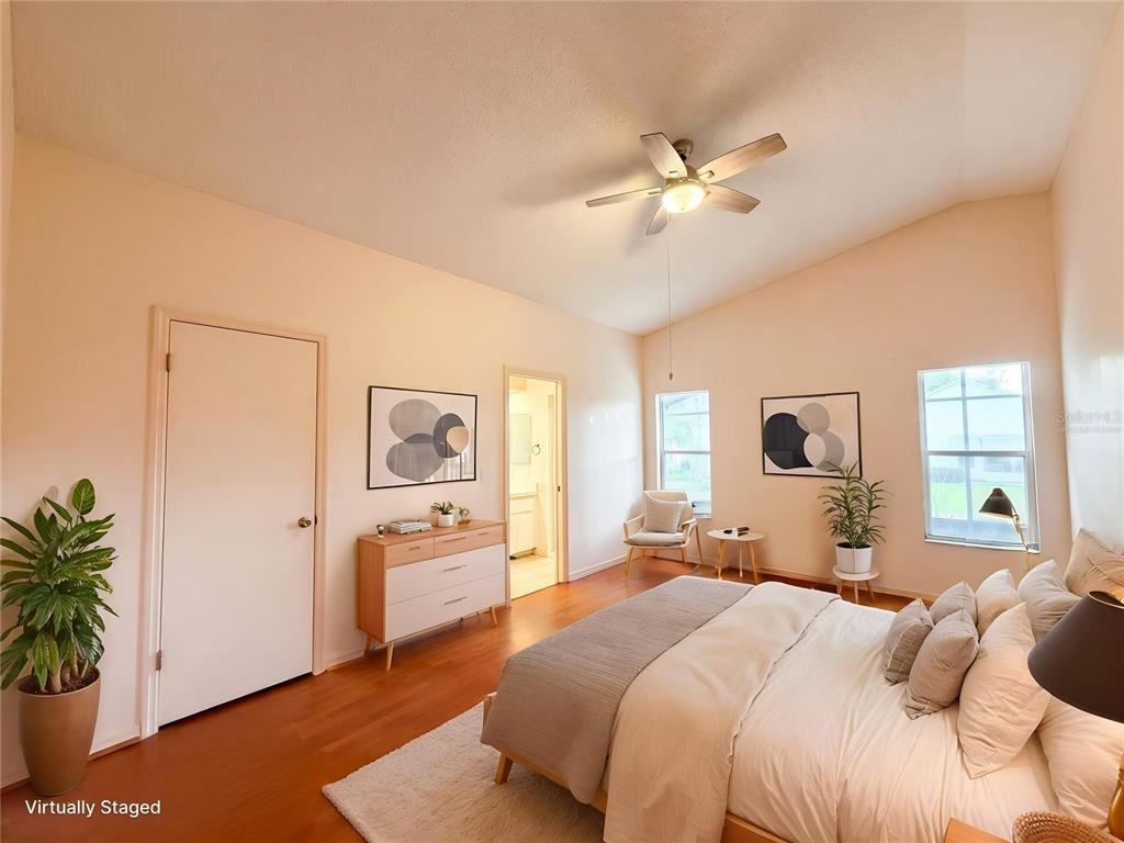 A bedroom with vaulted ceilings, hardwood floors, a ceiling fan, and a bed — 5507 LAVER STREET, LEESBURG, FL