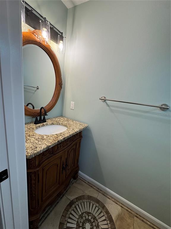 A small bathroom features a white toilet, a towel bar, and a circular flamingo stained-glass window — 143 GRANDE ISLAND BLVD BOULEVARD, PANAMA CITY BEACH, FL