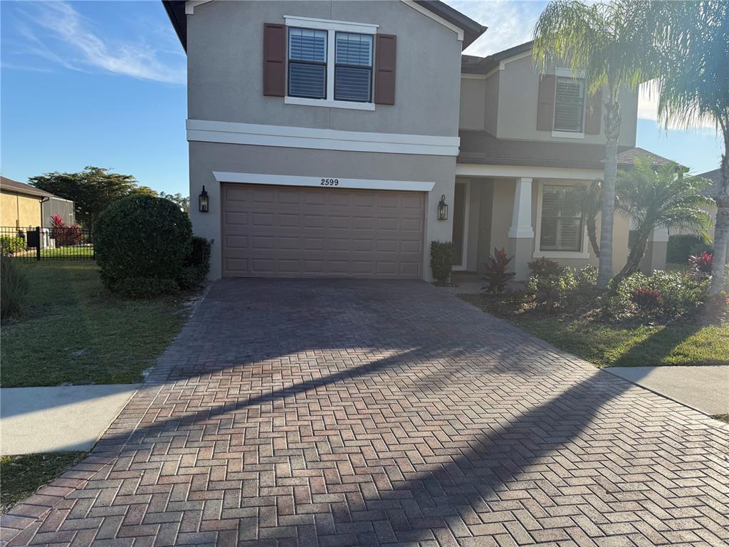 A two-story house features a paved driveway, a two-car garage, and a palm tree — 2599 MARTON OAK BOULEVARD, NORTH PORT, FL