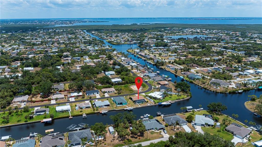 An aerial view shows a waterfront house with a red location pin on a canal — 18451 GOODMAN CIRCLE, PORT CHARLOTTE, FL