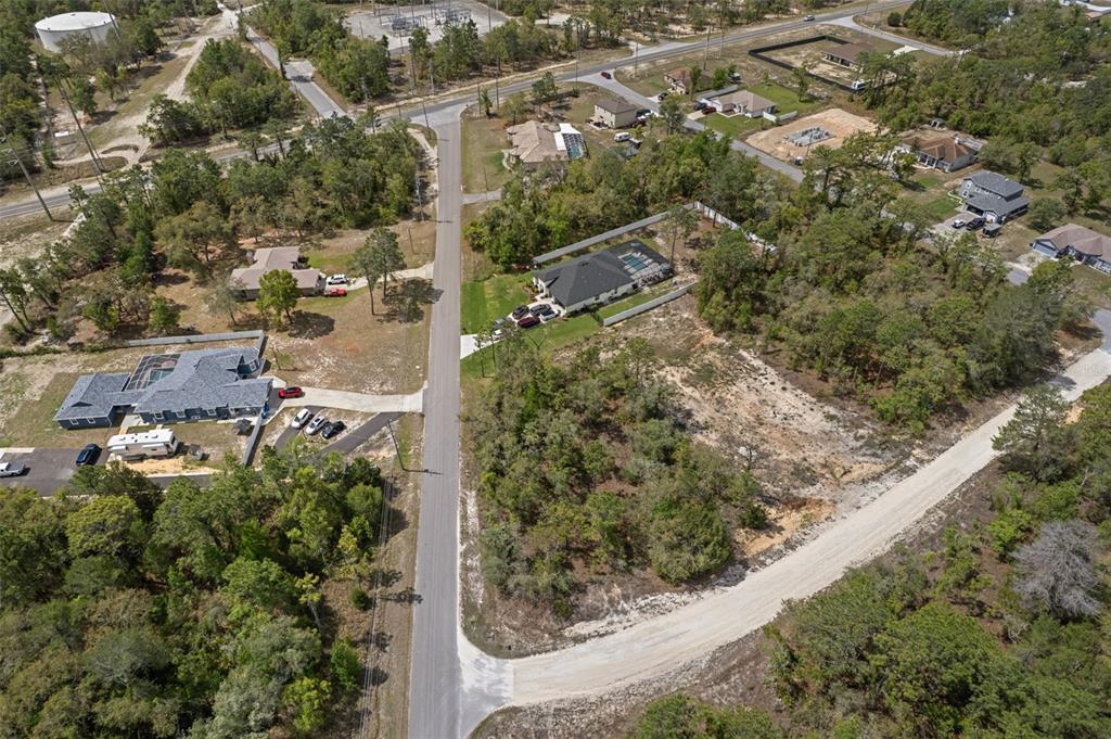 An aerial view shows a residential neighborhood with houses, wooded lots, and paved roads — 12140 MISSISSIPPI KITE AVENUE, BROOKSVILLE, FL