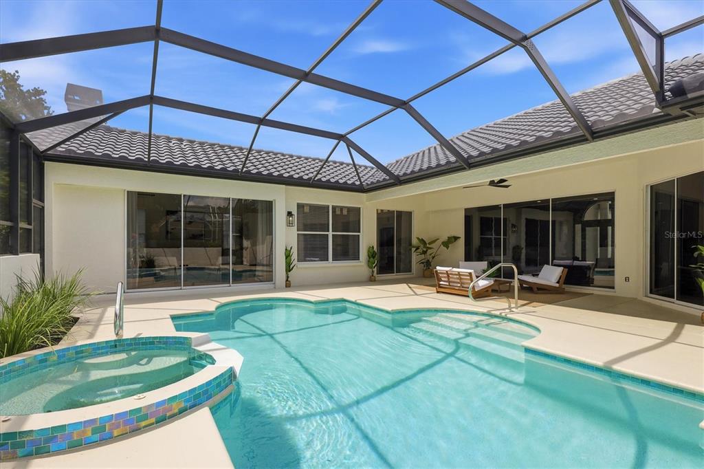 A screened-in patio features a swimming pool with an attached spa and outdoor seating — 7825 WILTON CRESCENT CIRCLE, BRADENTON, FL