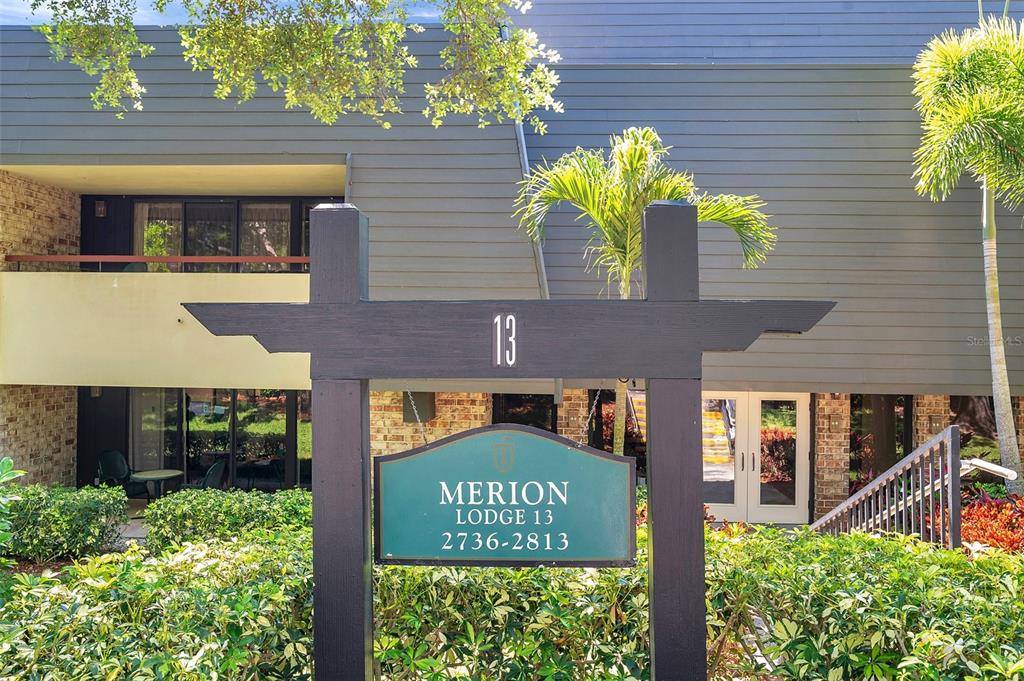 A sign for Merion Lodge 13 stands in front of a two-story building with balconies — 36750 US 19 N UNIT 2763, PALM HARBOR, FL