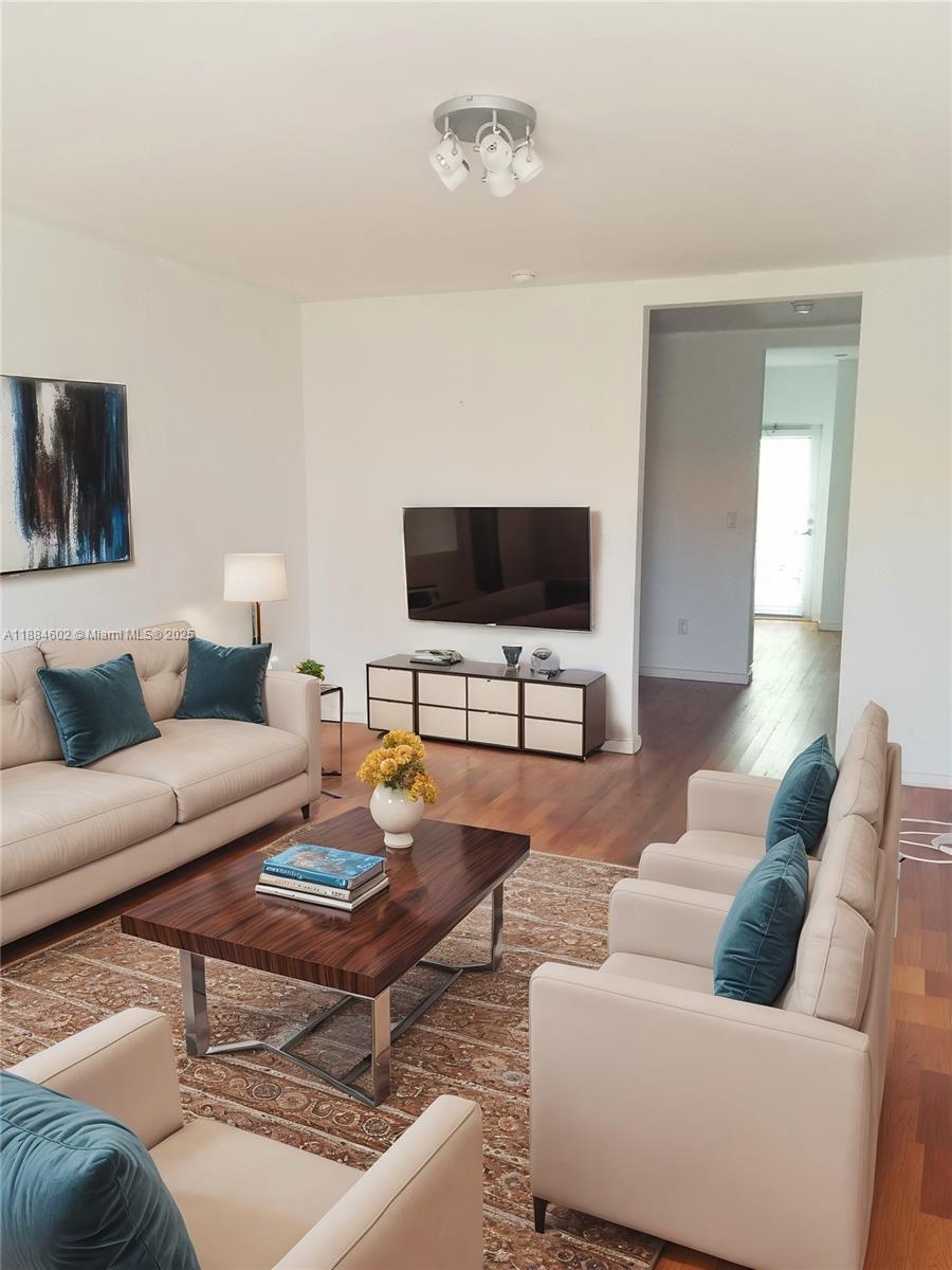 A living room features a beige sofa, matching armchairs, a wood coffee table, and a television — 745 13th St # 16, Miami Beach FL 33139, MIAMI BEACH, FL