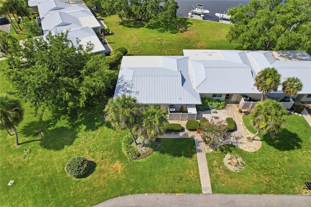 An aerial view shows a single-story residential building with a metal roof near water — 11628 W BAYSHORE DRIVE UNIT 8, CRYSTAL RIVER, FL