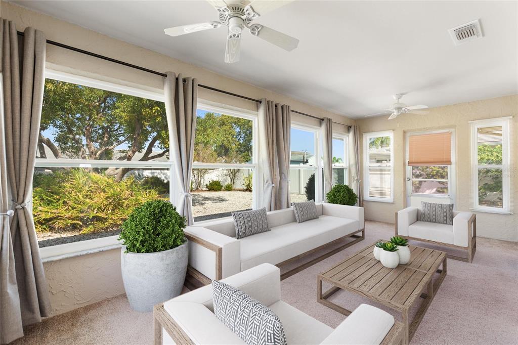 A sunroom with a sofa, armchairs, a coffee table, and large windows overlooking a yard — 679 FORT DUQUESNA DRIVE, SUN CITY CENTER, FL