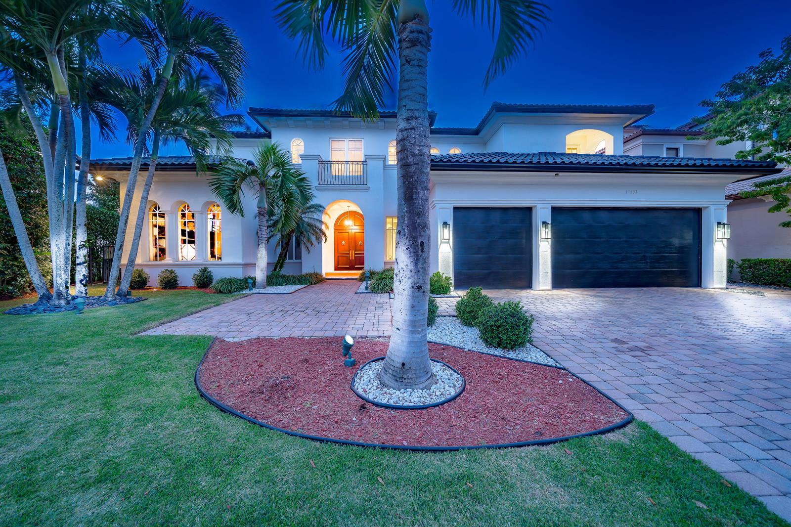 A two-story house with a paved driveway, a two-car garage, and palm trees at dusk — 17593 Middle Lake Drive, Boca Raton FL 33496, BOCA RATON, FL