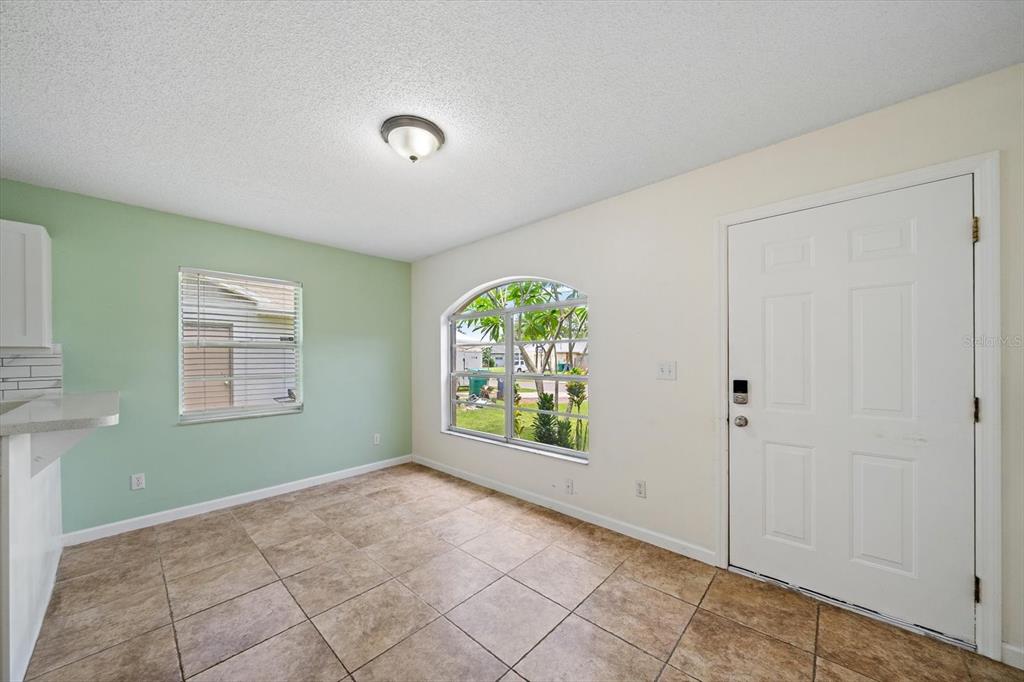 An empty room with tile floors, a green accent wall, and an arched window — 1521 13TH STREET W, PALMETTO, FL
