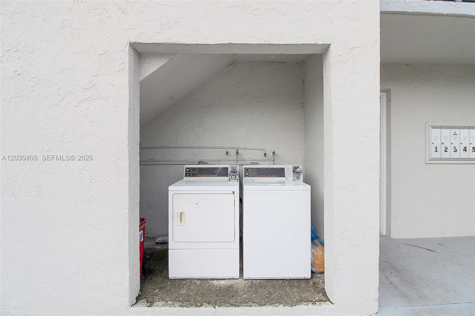 Two white laundry machines are located in an outdoor alcove next to mailboxes — 10745 SW 3rd St # 6, Sweetwater FL 33174, SWEETWATER, FL