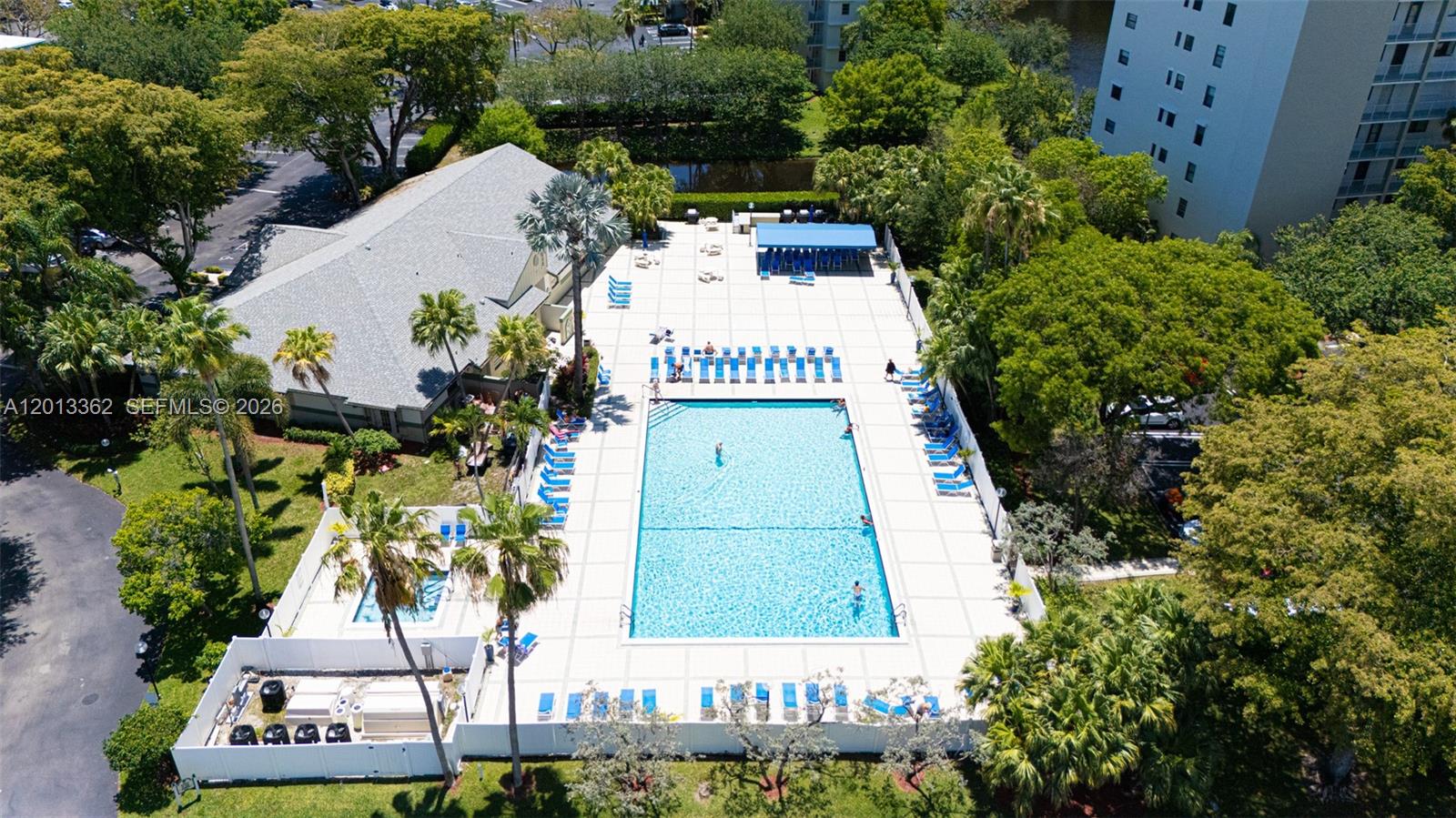 An aerial view shows a rectangular swimming pool surrounded by a patio and lounge chairs — 2232 N Cypress Bend Dr # 507, Pompano Beach FL 33069, POMPANO BEACH, FL