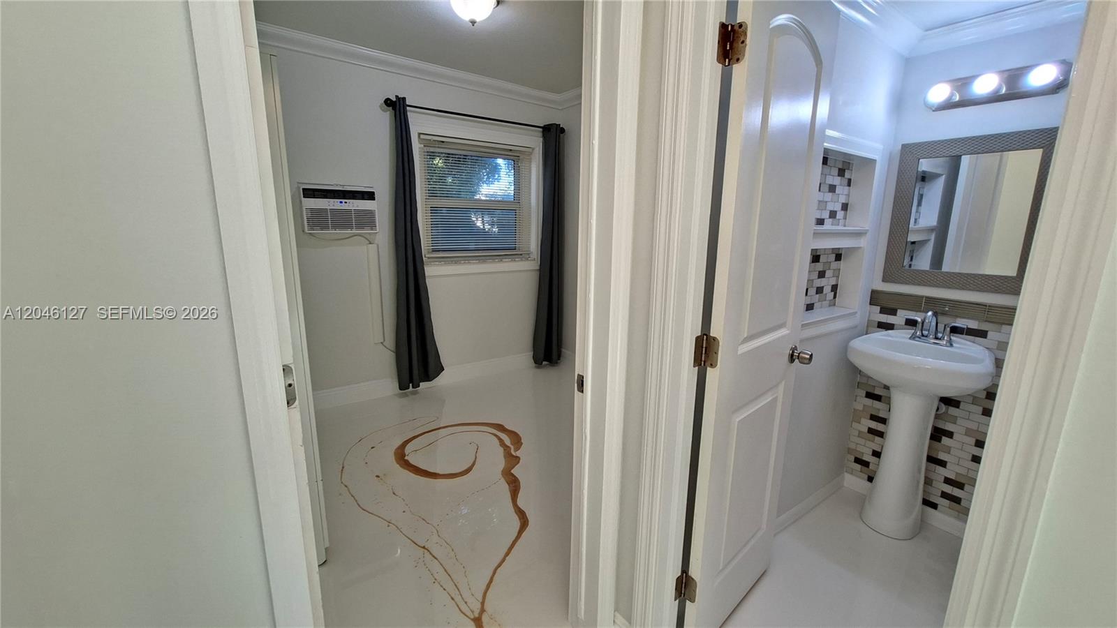 A room with a floor swirl design and an adjacent bathroom with a pedestal sink — 1028 S 62nd Ave # B, Hollywood FL 33023, HOLLYWOOD, FL