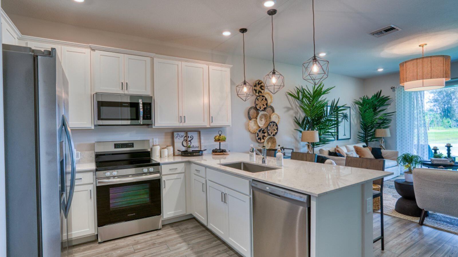 A kitchen with white cabinets, stainless steel appliances, and a quartz island countertop — 3616 Spanish Cedar Place, Fort Pierce FL 34946, FORT PIERCE, FL