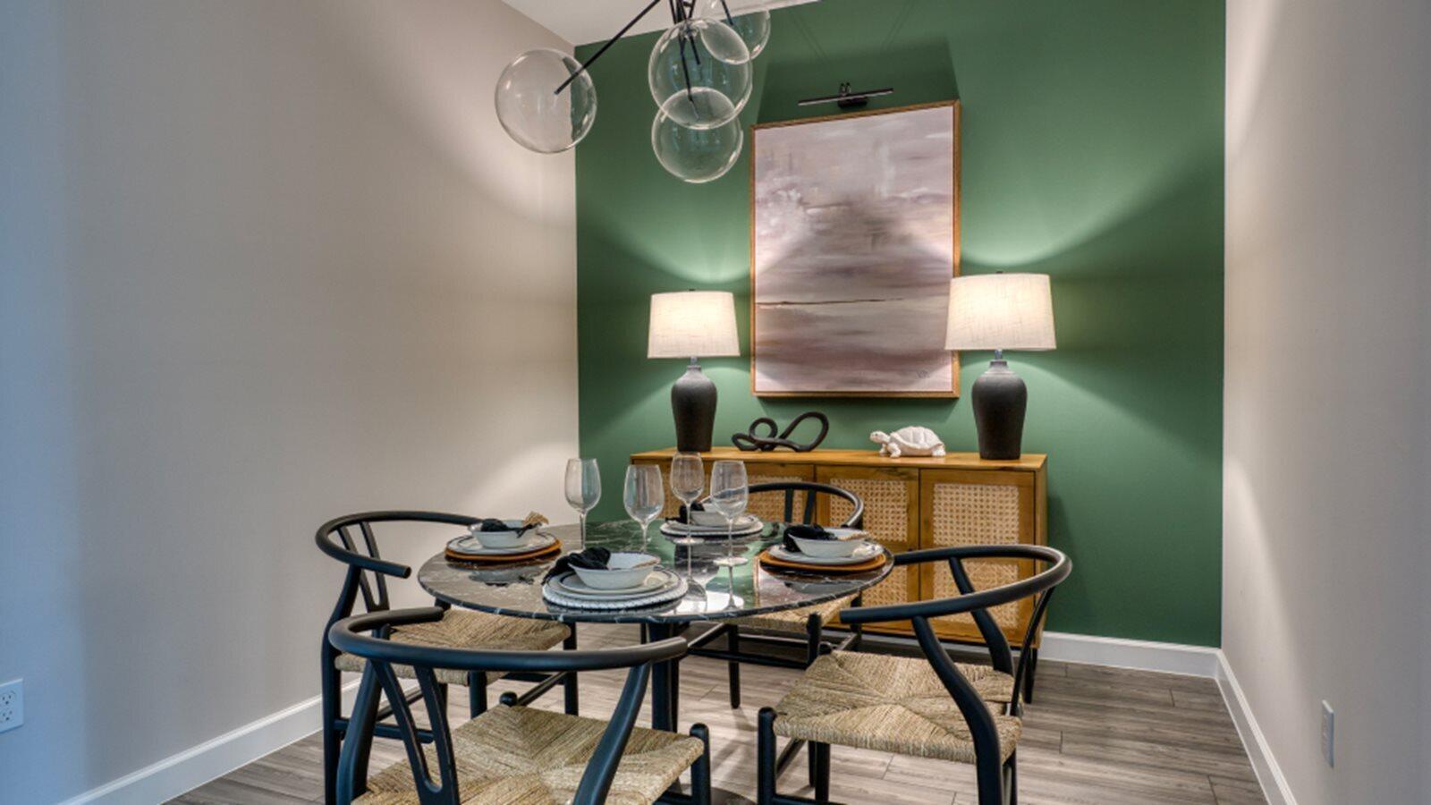 A dining room features a round marble table, black chairs, and a green accent wall — 3616 Spanish Cedar Place, Fort Pierce FL 34946, FORT PIERCE, FL