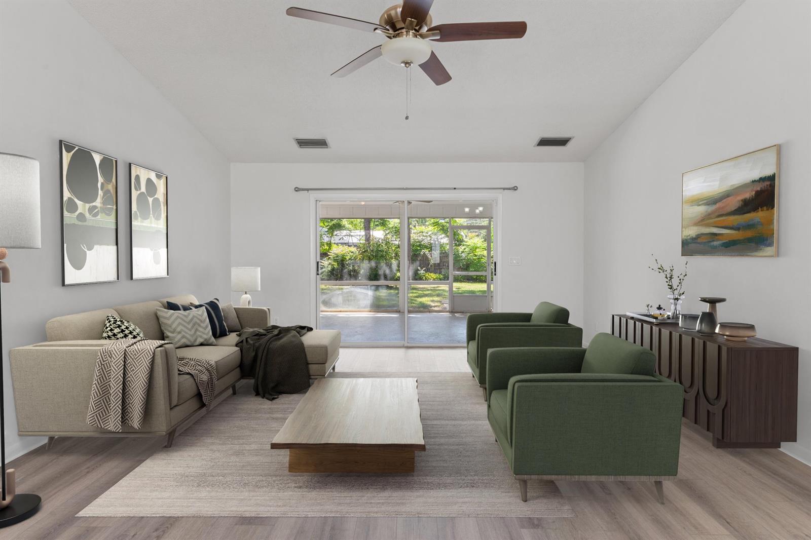 A living room features a sectional sofa, two green armchairs, a coffee table, and sliding doors — VERO BEACH, FL
