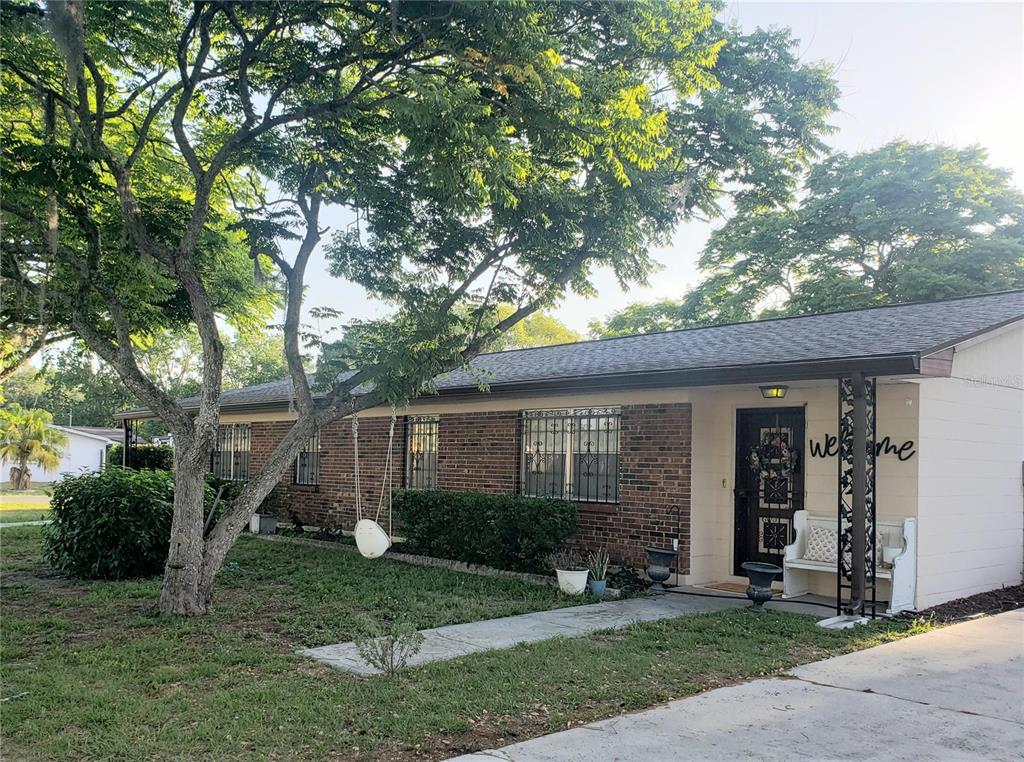 A single-story brick house with a front porch, a tree swing, and a white bench — 5652 18TH STREET, ZEPHYRHILLS, FL