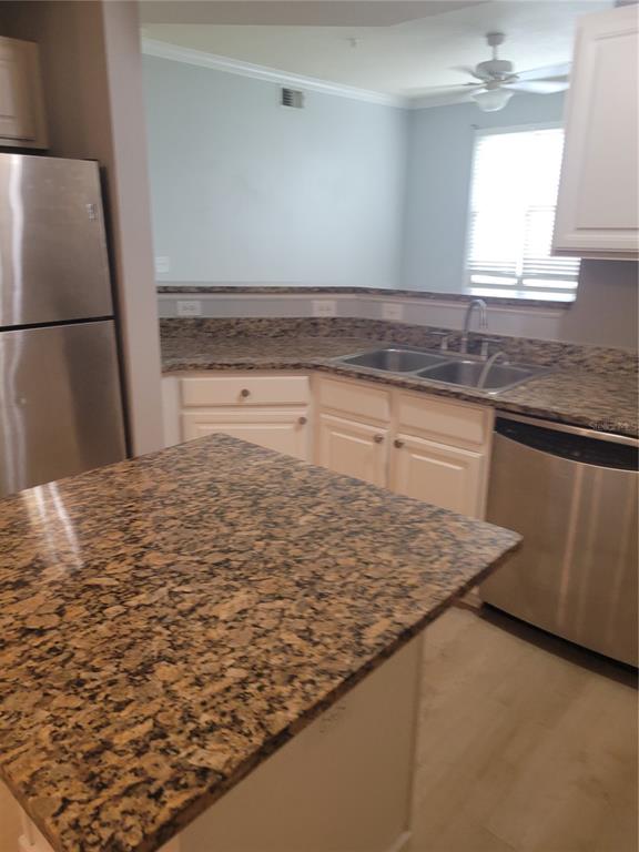 A kitchen features granite countertops, white cabinets, stainless steel appliances, and a central island — 501 KNIGHTS RUN AVENUE UNIT 1113, TAMPA, FL