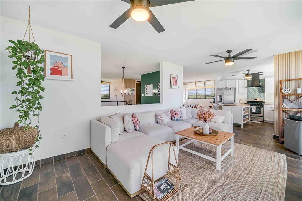 A living room with a white sectional sofa, wood coffee table, and open kitchen area — 1893 AVENIDA MANUELA LAMELA ABREU, ISABELA, PR