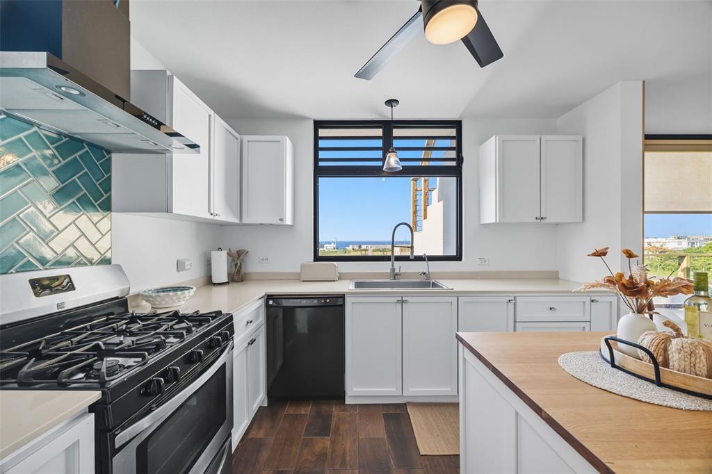 A modern kitchen features white cabinetry, a gas range, a dishwasher, and a windowed sink — 1893 AVENIDA MANUELA LAMELA ABREU, ISABELA, PR