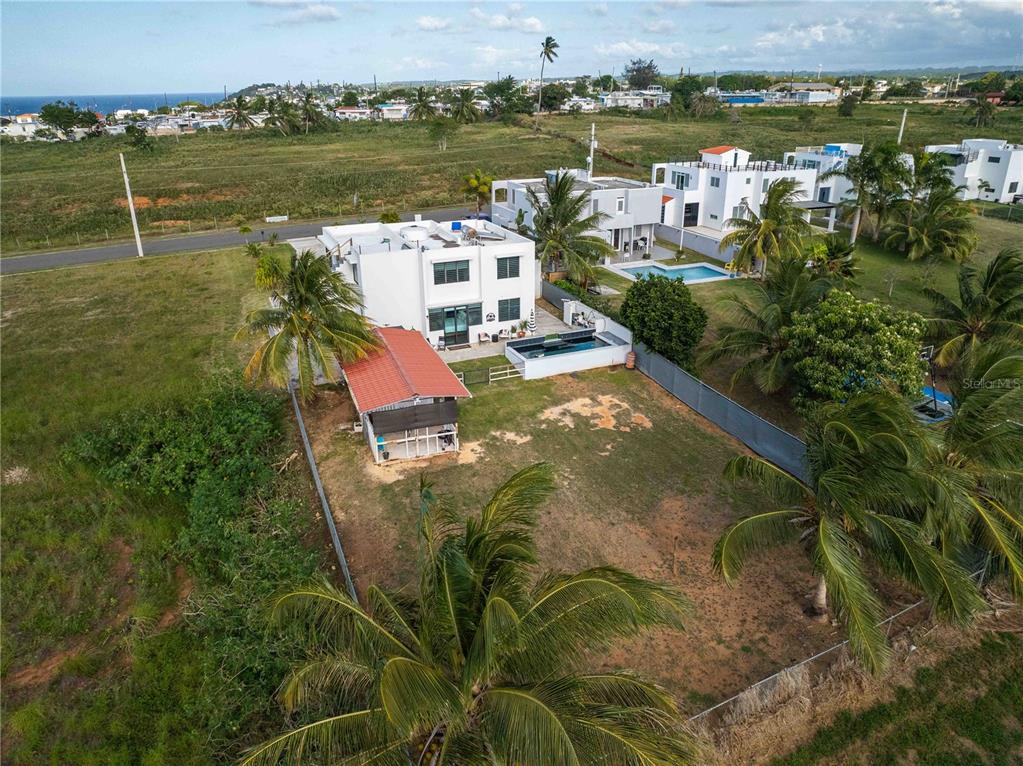 An aerial view shows a modern white house with a pool and a detached shed — 1893 AVENIDA MANUELA LAMELA ABREU, ISABELA, PR