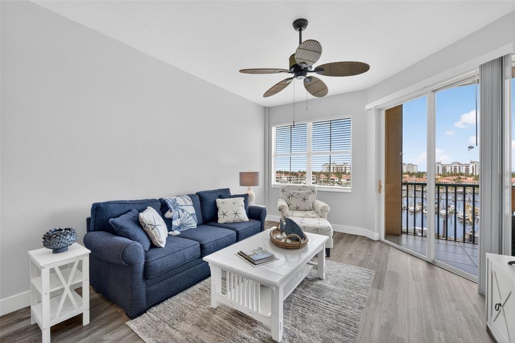 A living room features a blue sofa, white coffee table, and a balcony overlooking a marina — 2090 MATECUMBE KEY ROAD UNIT 1603, PUNTA GORDA, FL