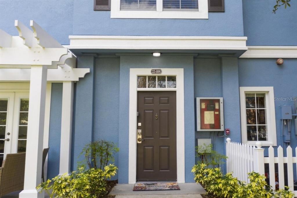 The exterior of a blue building features a brown front door with a white frame — 2201 SAN VITTORINO CIRCLE UNIT 108, KISSIMMEE, FL
