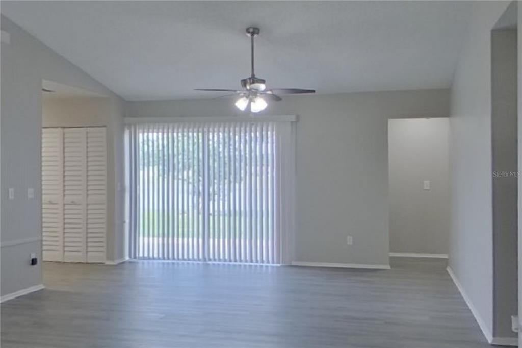 A living room with light gray flooring, a ceiling fan, and sliding glass patio doors — 39 TROTTERS CIRCLE, KISSIMMEE, FL