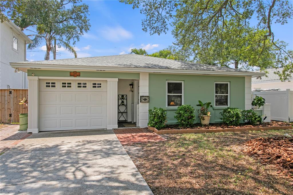 A single-story house with a green exterior, a white garage door, and a brick walkway — 508 COLUMBIA DRIVE, TAMPA, FL
