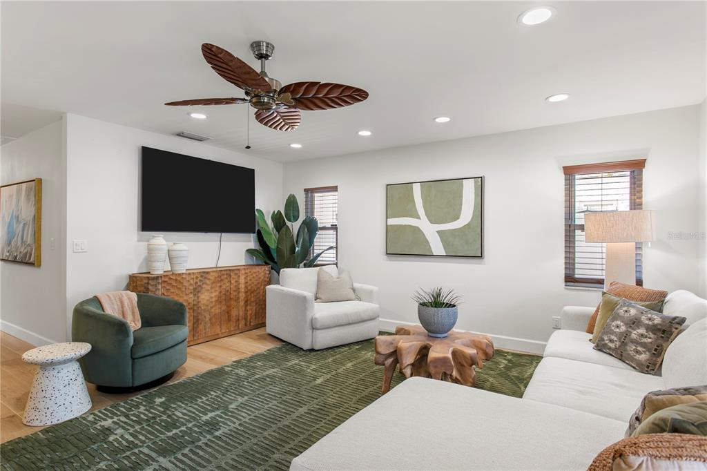 A living room features a white sectional, green armchair, wooden coffee table, and ceiling fan — 508 COLUMBIA DRIVE, TAMPA, FL