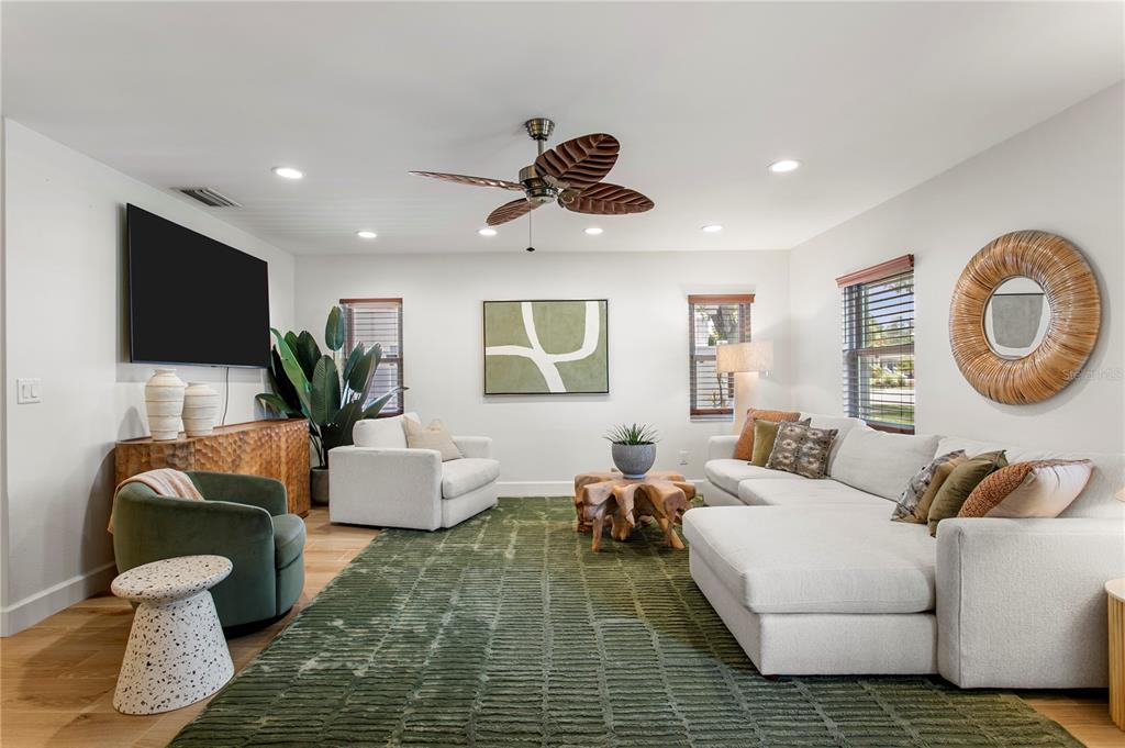 A living room features a white sectional sofa, green armchair, area rug, and ceiling fan — 508 COLUMBIA DRIVE, TAMPA, FL