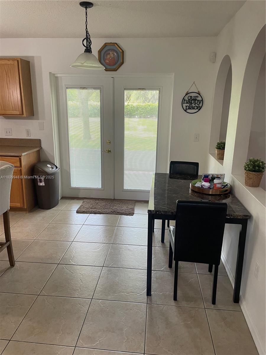 A kitchen dining area features tile flooring, a marble-topped table, and glass-paned double doors — 2645 SW 12th Sq SW, Vero Beach FL 32968, VERO BEACH, FL