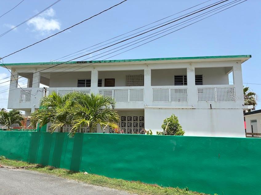 A two-story white house with a green roof and a green perimeter wall — PR-187 VILLA KENNEDY COMMUNITY LOT 149, LOIZA, PR