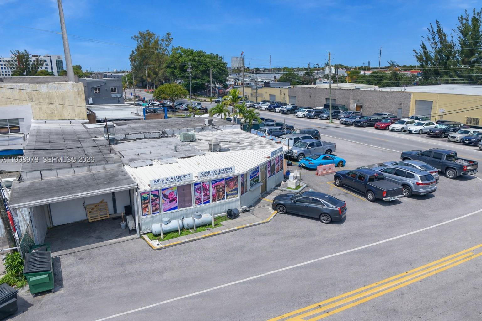 An aerial view shows a single-story restaurant building with a parking lot and surrounding street — 3300 NW South River Dr, Miami FL 33142, MIAMI, FL