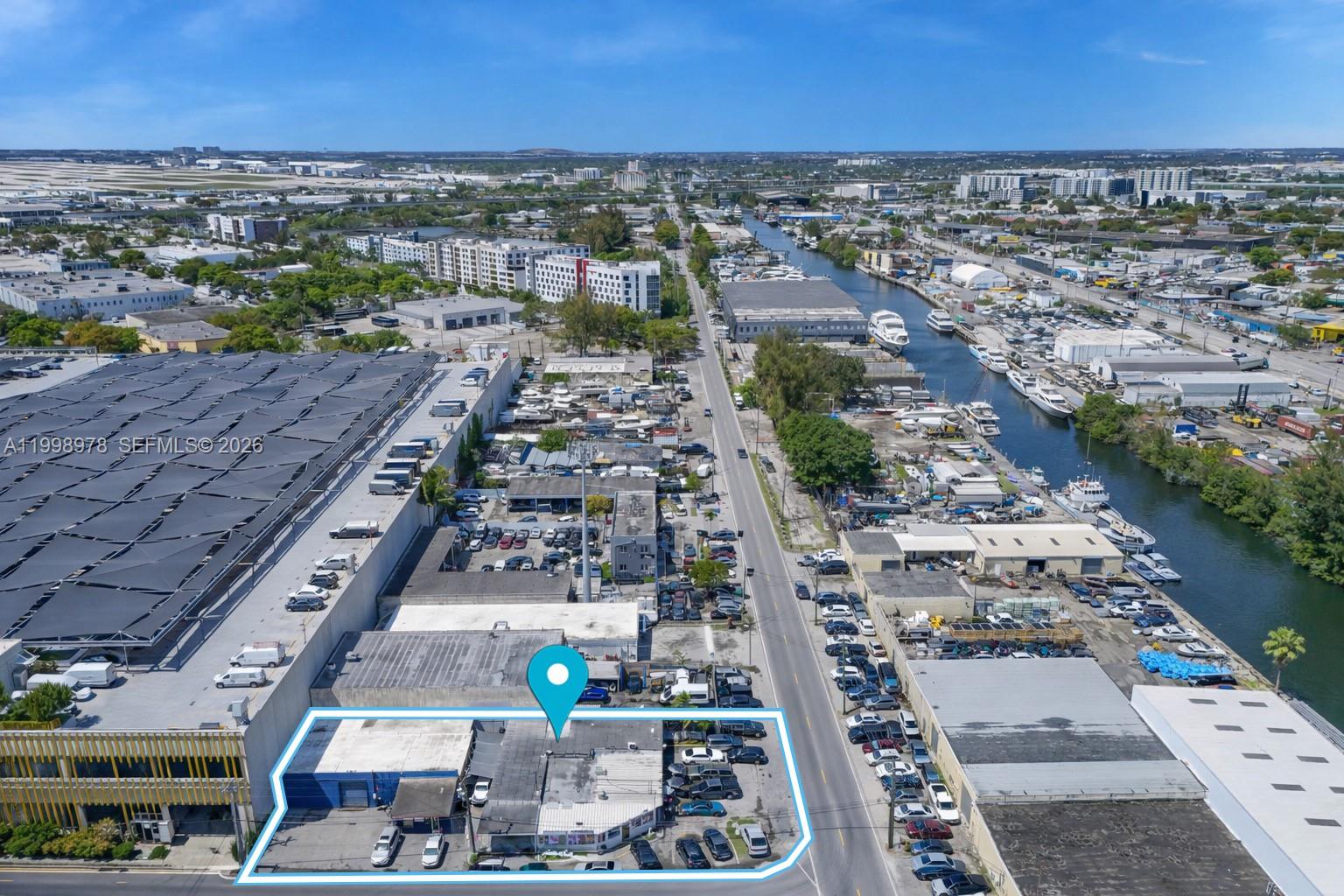 An aerial view shows a commercial building outlined in blue along a busy street — 3300 NW South River Dr, Miami FL 33142, MIAMI, FL