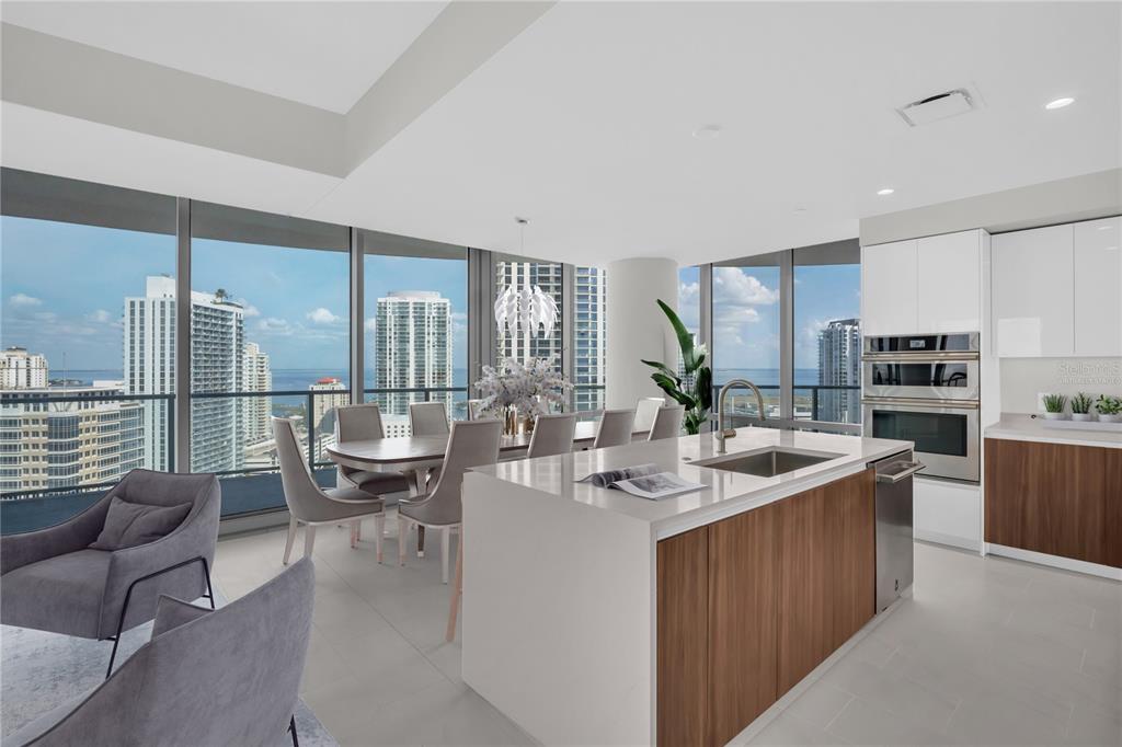 A modern kitchen and dining area with floor-to-ceiling windows overlooking a city skyline — 400 CENTRAL AVENUE UNIT 2207, ST PETERSBURG, FL