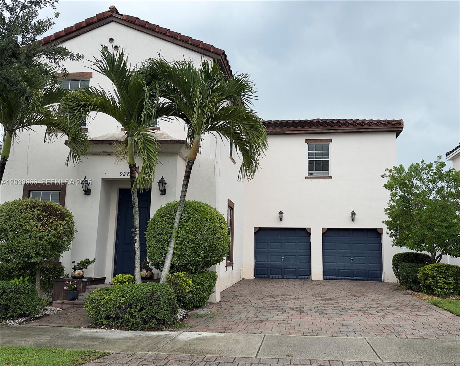 A two-story stucco house features a tiled roof, two garage doors, and palm trees — 9273 SW 172nd Ave # 9273, Miami FL 33196, MIAMI, FL