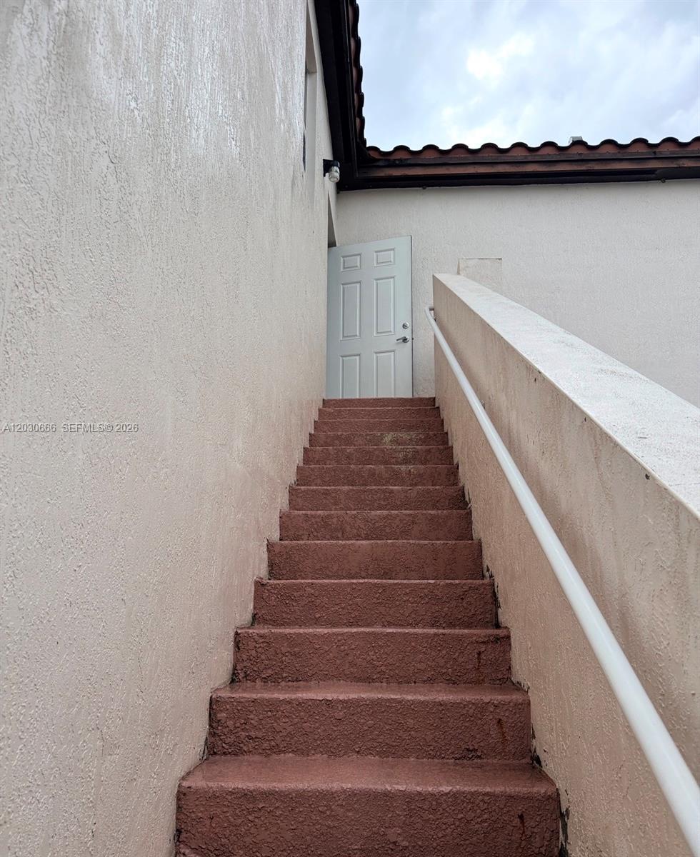 An exterior staircase with a white handrail leads up to a white door — 9273 SW 172nd Ave # 9273, Miami FL 33196, MIAMI, FL