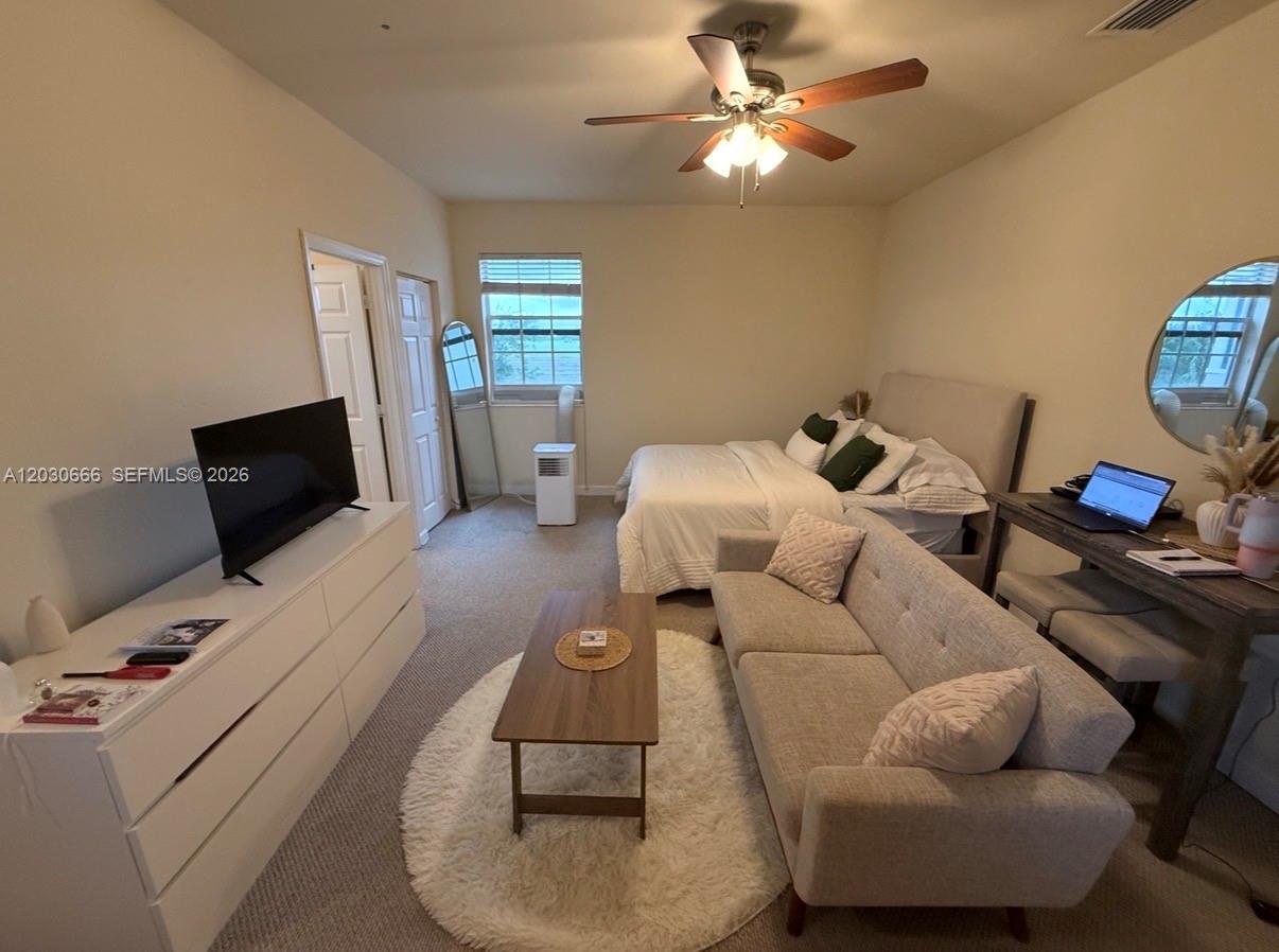 This bedroom features a bed, a sofa, a television on a dresser, and carpeted flooring — 9273 SW 172nd Ave # 9273, Miami FL 33196, MIAMI, FL