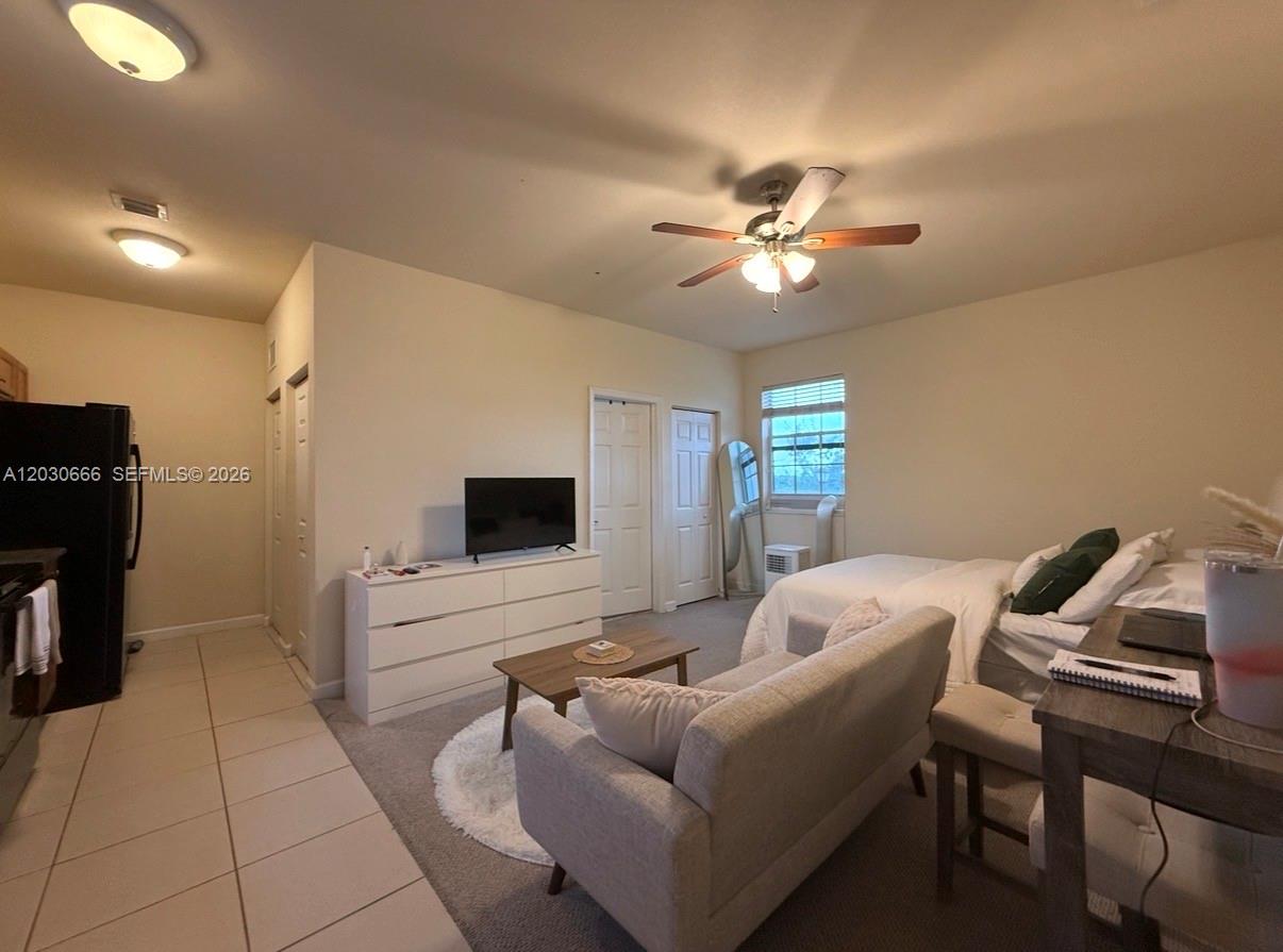 A studio apartment features a bed, sofa, television on a dresser, and tiled kitchen area — 9273 SW 172nd Ave # 9273, Miami FL 33196, MIAMI, FL