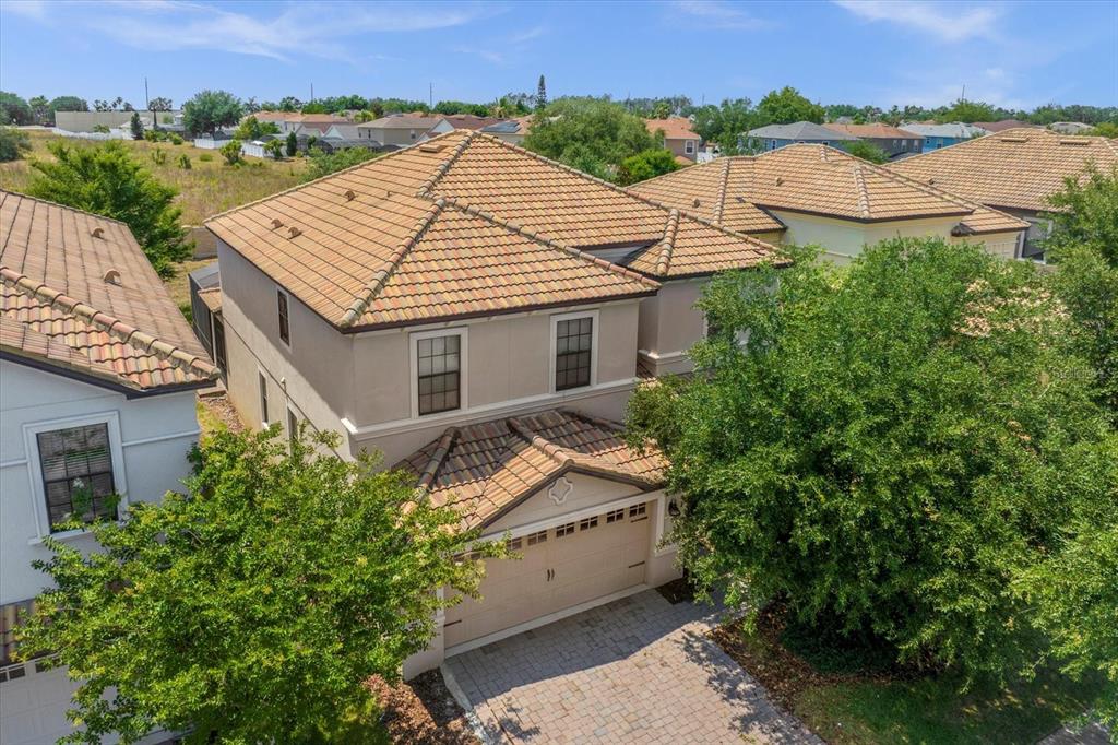 An aerial view of a two-story house with a tiled roof and a paved driveway — 1483 ROLLING FAIRWAY DRIVE, CHAMPIONS GATE, FL