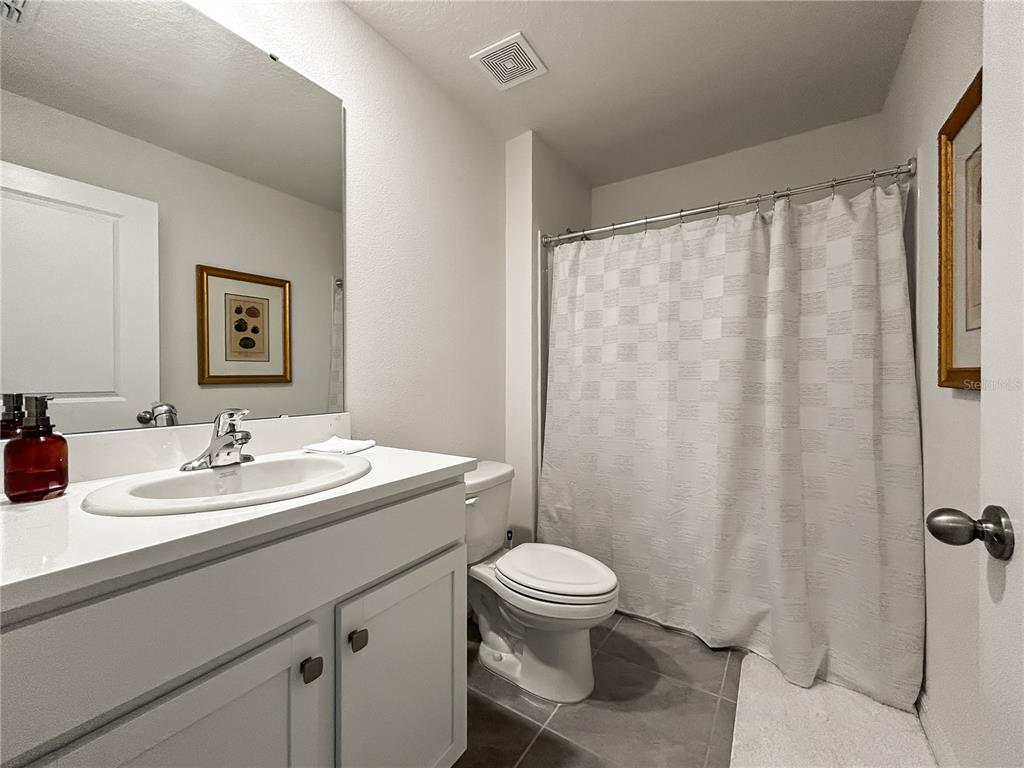 A bathroom features a white vanity, a toilet, and a shower with a white curtain — 16820 SW 29TH TERRACE ROAD, OCALA, FL