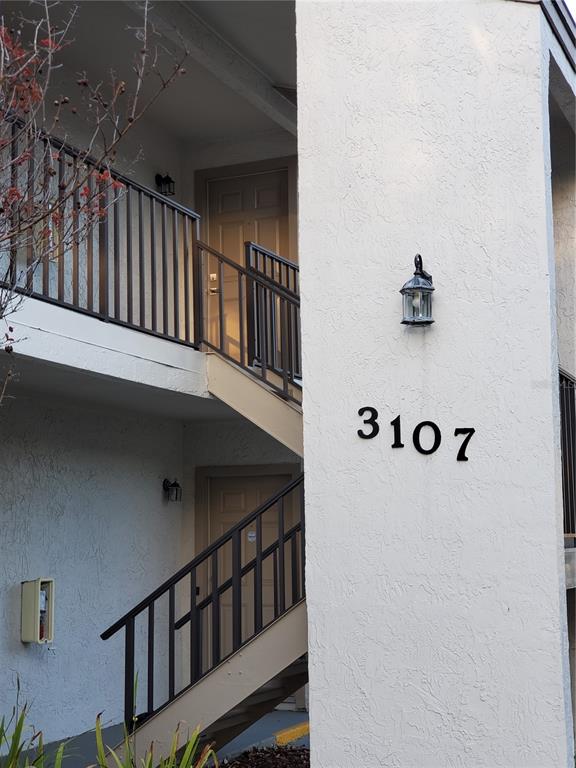 An exterior view of a two-story apartment building with stairs leading to the upper unit — 3107 W HORATIO STREET UNIT B22, TAMPA, FL
