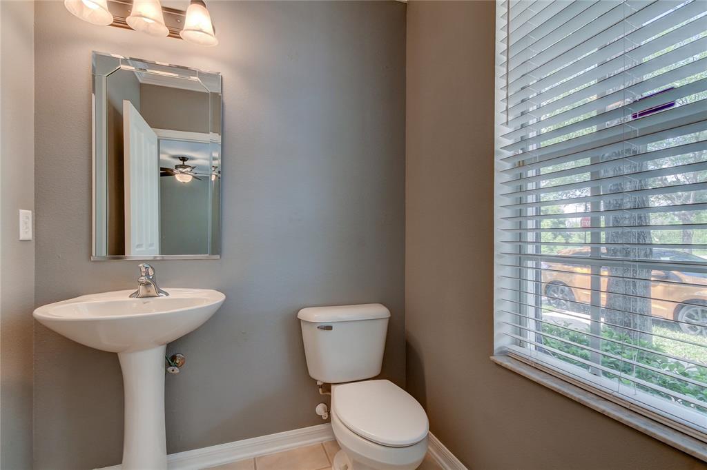 A bathroom with a pedestal sink, a toilet, a mirror, and a window with blinds — 10003 BRADWELL PLACE, TAMPA, FL