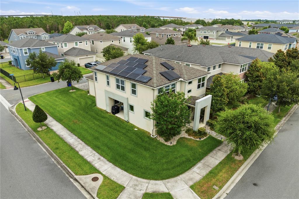 An aerial view of a two-story suburban house with solar panels on the roof — 16185 TALIESIN STREET, WINTER GARDEN, FL