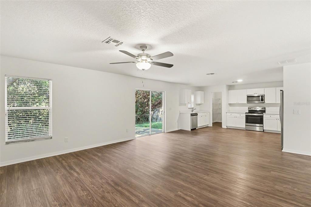 A two-story house with brown stucco siding, a white garage, and a front lawn — 1544 ALGONKIN LOOP, ORLANDO, FL
