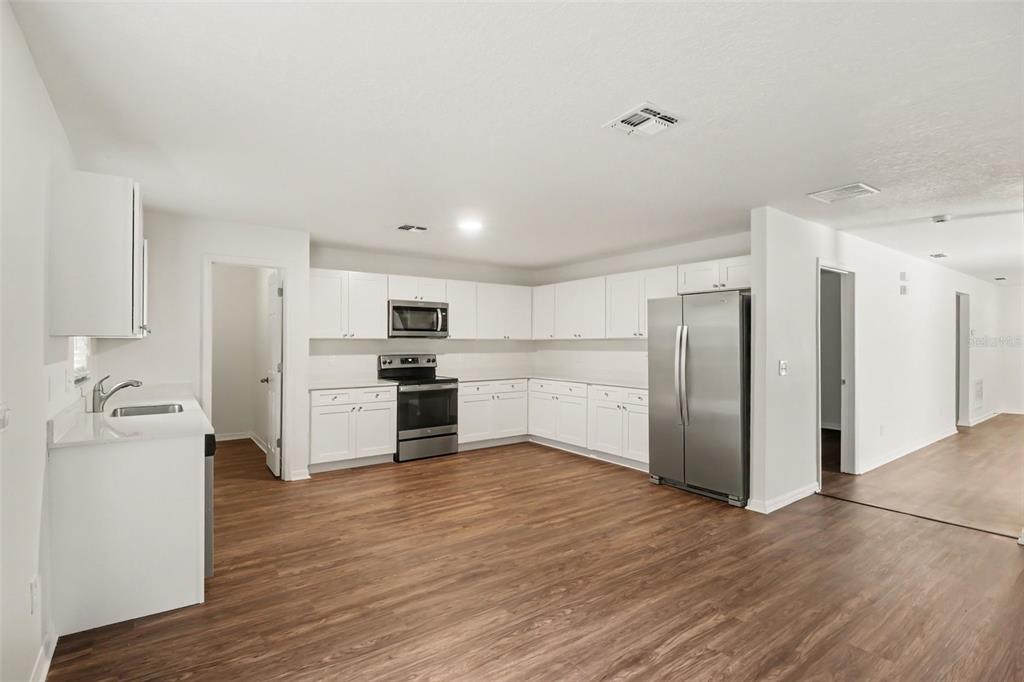 A two-story house with a brown stucco exterior, a white garage door, and a walkway — 1544 ALGONKIN LOOP, ORLANDO, FL