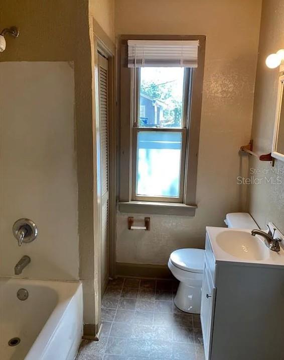 A bathroom features a white bathtub, a pedestal sink, a toilet, and a window — 110 W 13TH STREET, SANFORD, FL