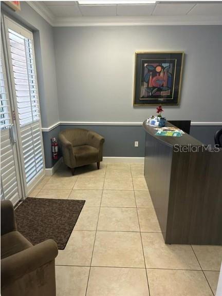 A reception area features a dark wood desk, a tan armchair, and light-colored tile flooring — 5245 OFFICE PARK BOULEVARD, BRADENTON, FL